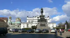 Сградата на Народното събрание в София с паметника на Цар Освободител, катедралата „Св. Александър Невски“ и паркирани коли